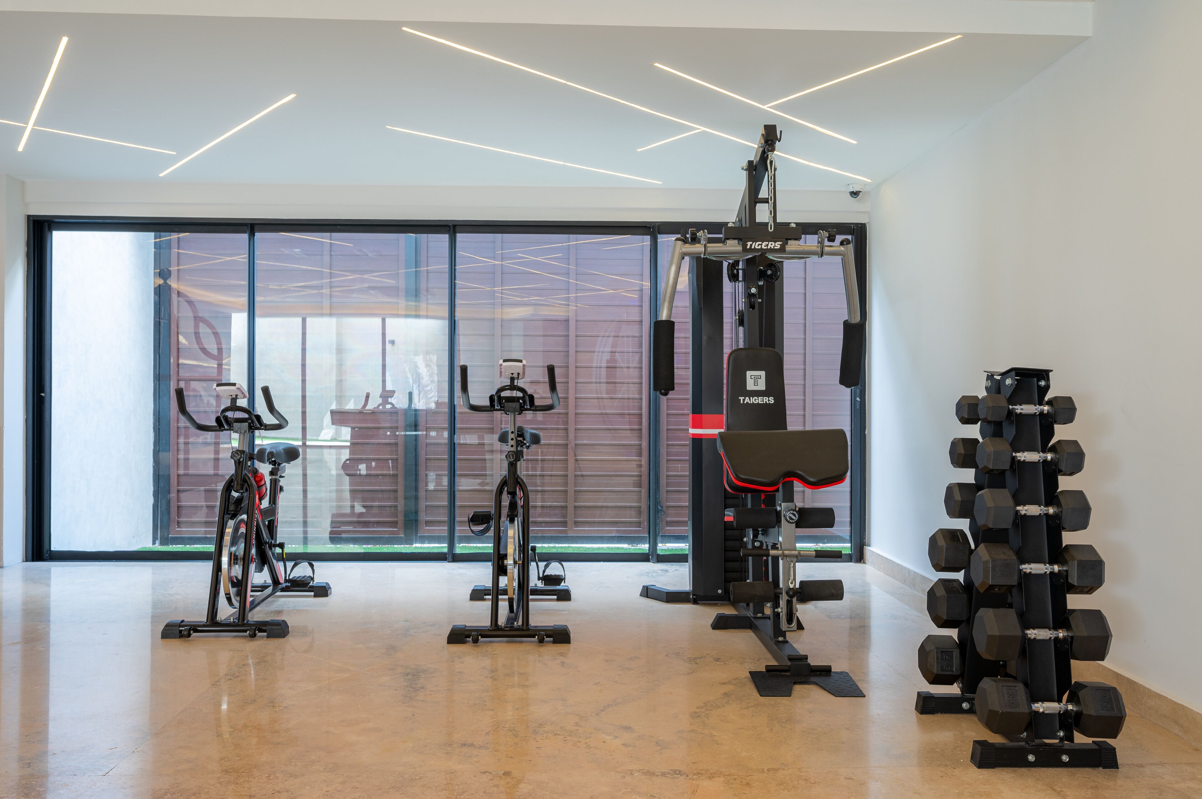Ett modernt gym med motionscyklar, en styrketräningsmaskin och ett ställ med hantlar.