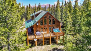 A wooden cabin with a balcony, surrounded by trees and mountains. - Wrap-Deck Hot Tub w/ Mt. Sherman Views - Fire Pit, Wildlife (Fairplay)