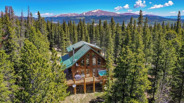 A cabin surrounded by dense forest with a mountain in the background. - Wrap-Deck Hot Tub w/ Mt. Sherman Views - Fire Pit, Wildlife (Fairplay)