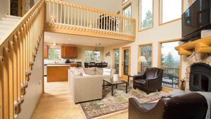 A spacious living area with a high ceiling, a fireplace, and a balcony. - Wrap-Deck Hot Tub w/ Mt. Sherman Views - Fire Pit, Wildlife (Fairplay)