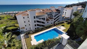 Un hôtel à plusieurs étages doté d’une piscine sur le toit et offrant une vue sur l’océan.