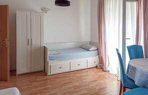 A bedroom with a single bed, a wardrobe, a chair, and a table. - 1 bedroom awesome apartment in Poljica (Poljica)