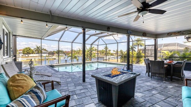 A covered outdoor area with a pool, seating, and a view of the surrounding landscape. - Luxury Contemporary Style House on Charlotte Harbor Area, Charlotte County House 5819 (Charlotte County)