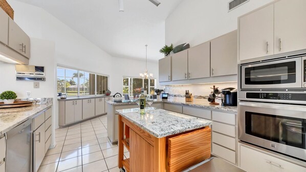 Enjoy cooking in this well-lit kitchen with a central island and stainless steel appliances.