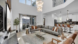 A spacious living area with a sectional sofa, a coffee table, and a dining area with modern chairs. - Luxury 5 Star House on Champions Gate Resort, Orlando Villa 6164 (Orlando)