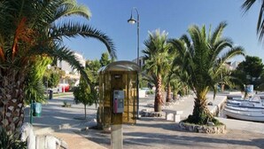 Une place publique avec un kiosque, des palmiers et une statue de chevaux.