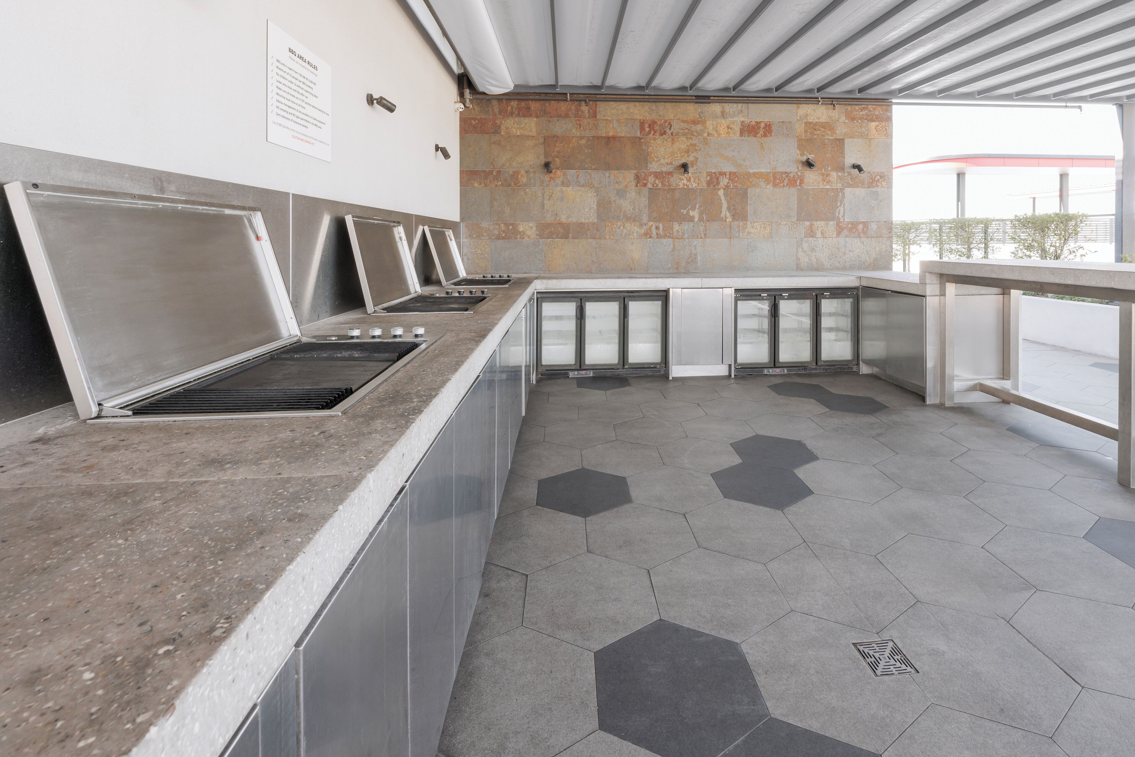 A commercial kitchen with stainless steel appliances and a hexagonal tile floor.