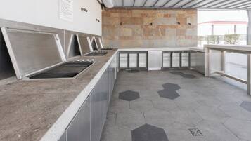 A commercial kitchen with stainless steel appliances and a hexagonal tile floor.