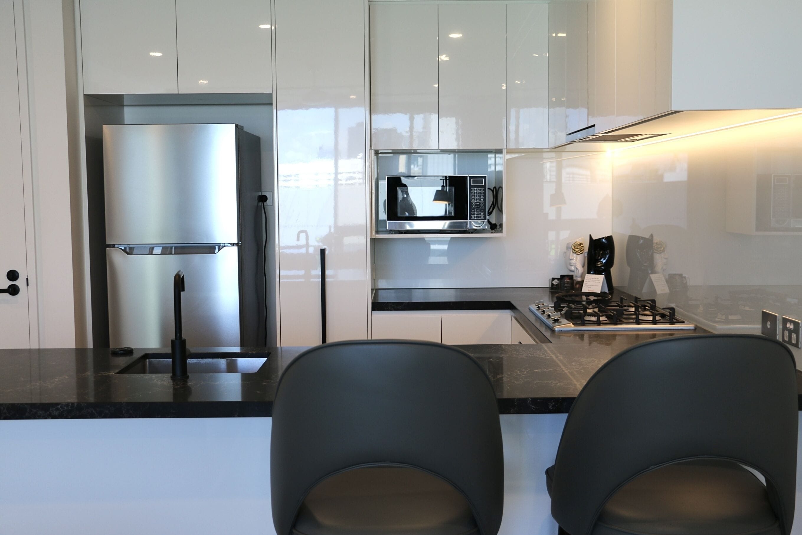 Une cuisine moderne équipée d’un réfrigérateur, d’un four à micro-ondes et d’une cuisinière à gaz.