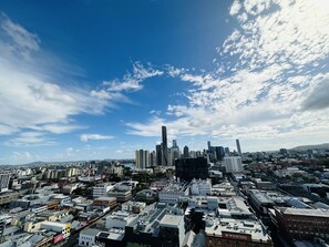 A cityscape with a variety of building heights and architectural styles, including modern skyscrapers and older, smaller structures. - Kooii Apartments (Fortitude Valley)