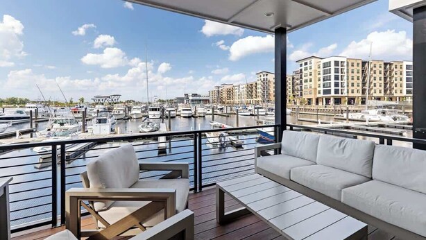Un balcón con vista a un puerto deportivo y edificios.