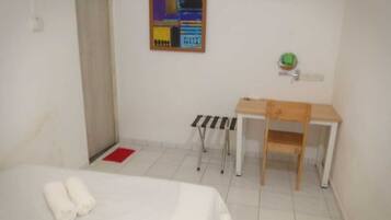 A room with a bed, a desk, and a chair.