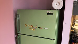 A green refrigerator with a freezer on top, a small shelf, and a handle on the door. - Natol Budget Homestay Rock Road (Kuching)