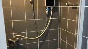 A shower with a handheld showerhead, a handheld shower attachment, and a control panel. - Natol Budget Homestay Rock Road (Kuching)