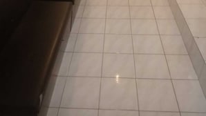A hallway with a black bench, tiled floor, and a door at the end. - Natol Budget Homestay Rock Road (Kuching)