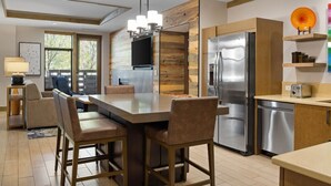 A modern kitchen with a central island, stainless steel appliances, and wooden accents.