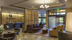 A reception area with a wooden reception desk, a leather sofa, and a seating area with chairs and a table.