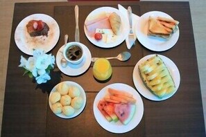 Una mesa con platos de comida, una taza y una cuchara.