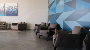 A waiting area with several armchairs and sofas, a patterned wall, and abstract paintings. - Transamerica Executive Taboão da Serra Morumbi (Taboão da Serra)