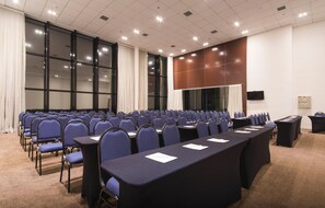 A conference room with rows of chairs, a long table, and a large screen. - Transamerica Executive Taboão da Serra Morumbi (Taboão da Serra)