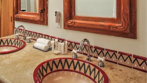 Ein Badezimmer mit zwei Waschbecken, jeweils mit roter Umrandung, und einem Spiegel darüber.