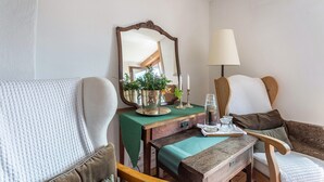 A room with a wooden desk, a mirror, a lamp, and a chair.
