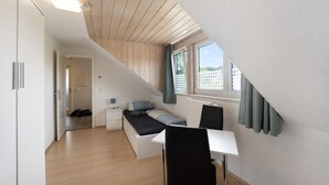 A bedroom with a loft bed, a desk, and a window with curtains. - Holiday Apartment "Sonnenbühl" with Lake View, Private Balcony and Wi-Fi (Aulendorf)