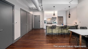 A modern kitchen with a central island, bar stools, and pendant lighting.
