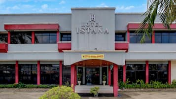 A hotel with a prominent sign reading 'HOTEL ISTANA' and a smaller sign below stating 'HOTEL ISTANA SVARIAH'.