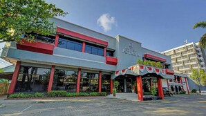 Een hotel met een moderne gevel, grote ramen en een opvallende entree met een decoratieve luifel.