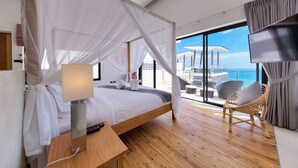Ein Schlafzimmer mit Bett, Nachttisch und Blick auf den Balkon.