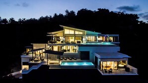 Ein modernes Mehrfamilienhaus mit Pool, mehreren Balkonen und großen Fenstern.