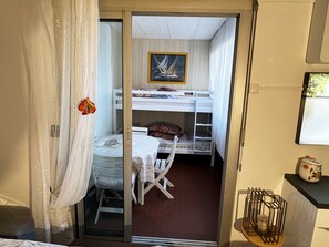 Cozy retreat with a single bed, bunk bed, and balcony access.