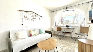 Un salon confortable avec un canapé, deux fauteuils, une petite table ronde et un élément décoratif mural.