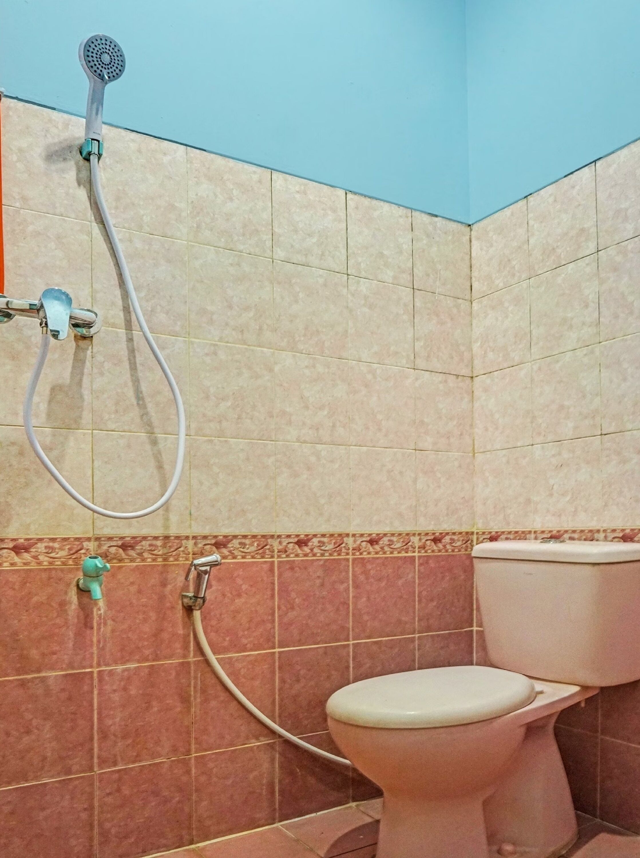 Un baño con ducha, inodoro y paredes de azulejos.