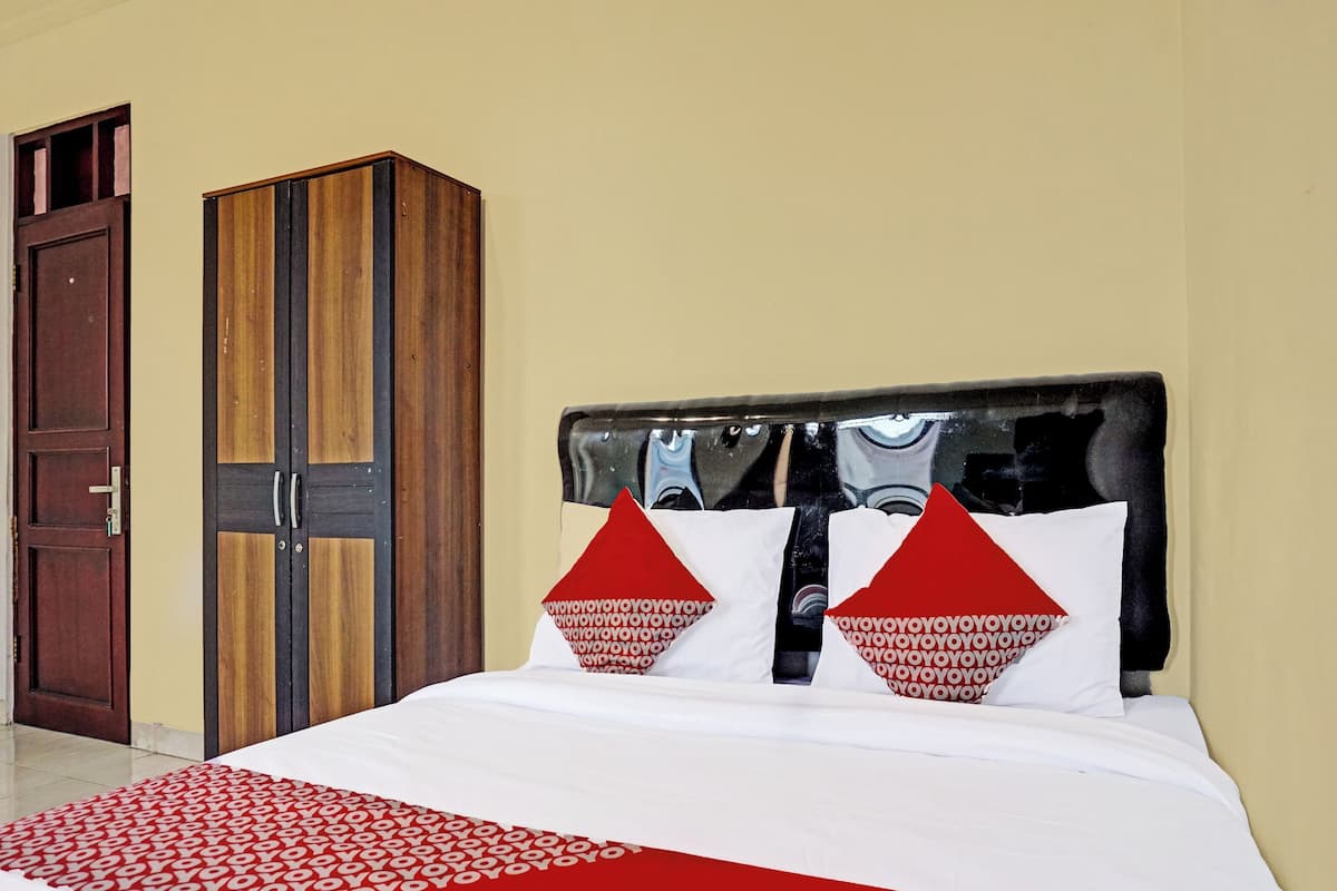 Une chambre d’hôtel avec un lit, une armoire et une porte.