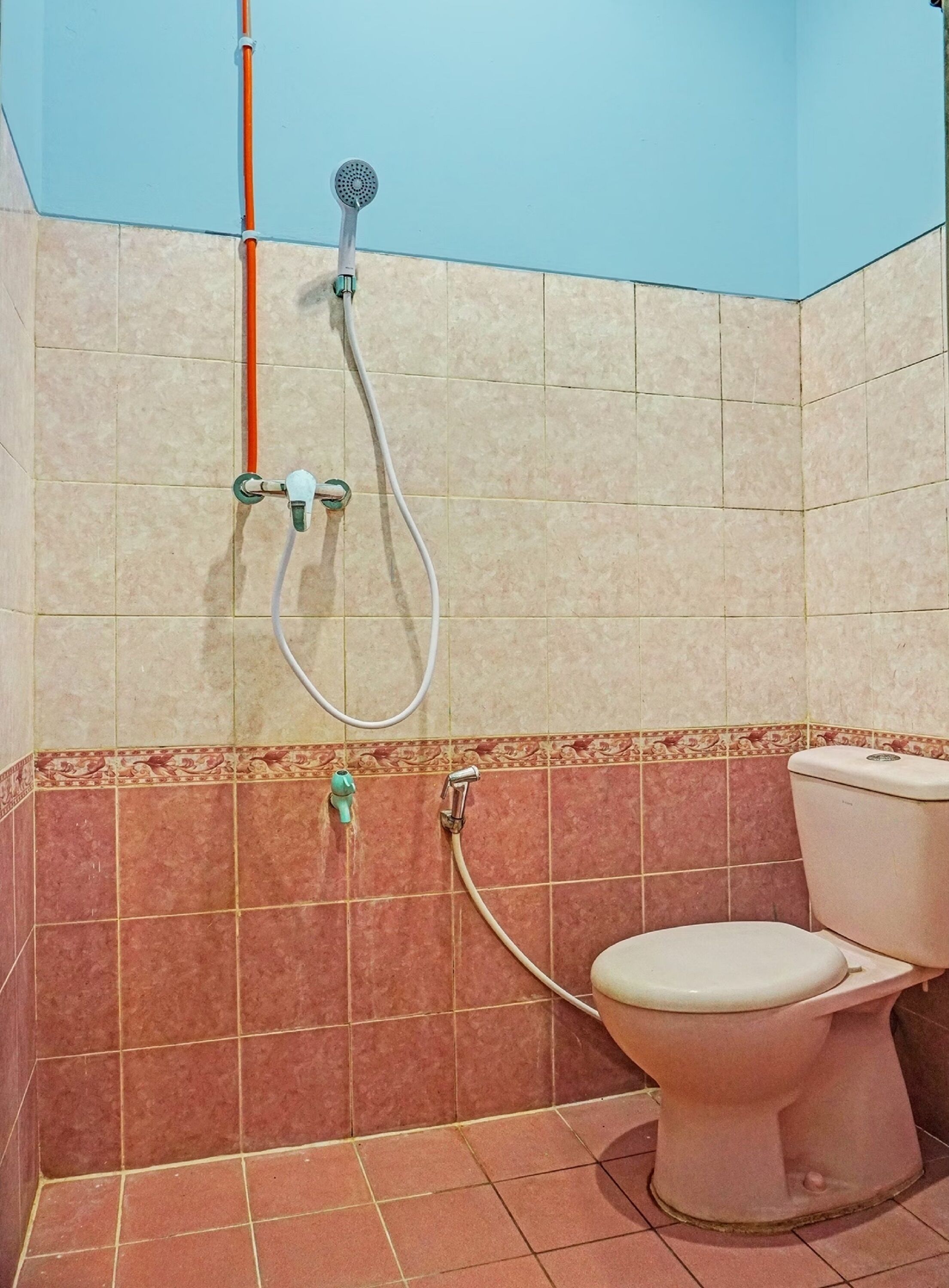 A bathroom with a toilet, a shower, and a sink.