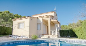 Un bâtiment à deux étages avec une piscine devant.