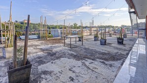 Tagterrasse med plantekasser, gelænder og udsigt over bybilledet.