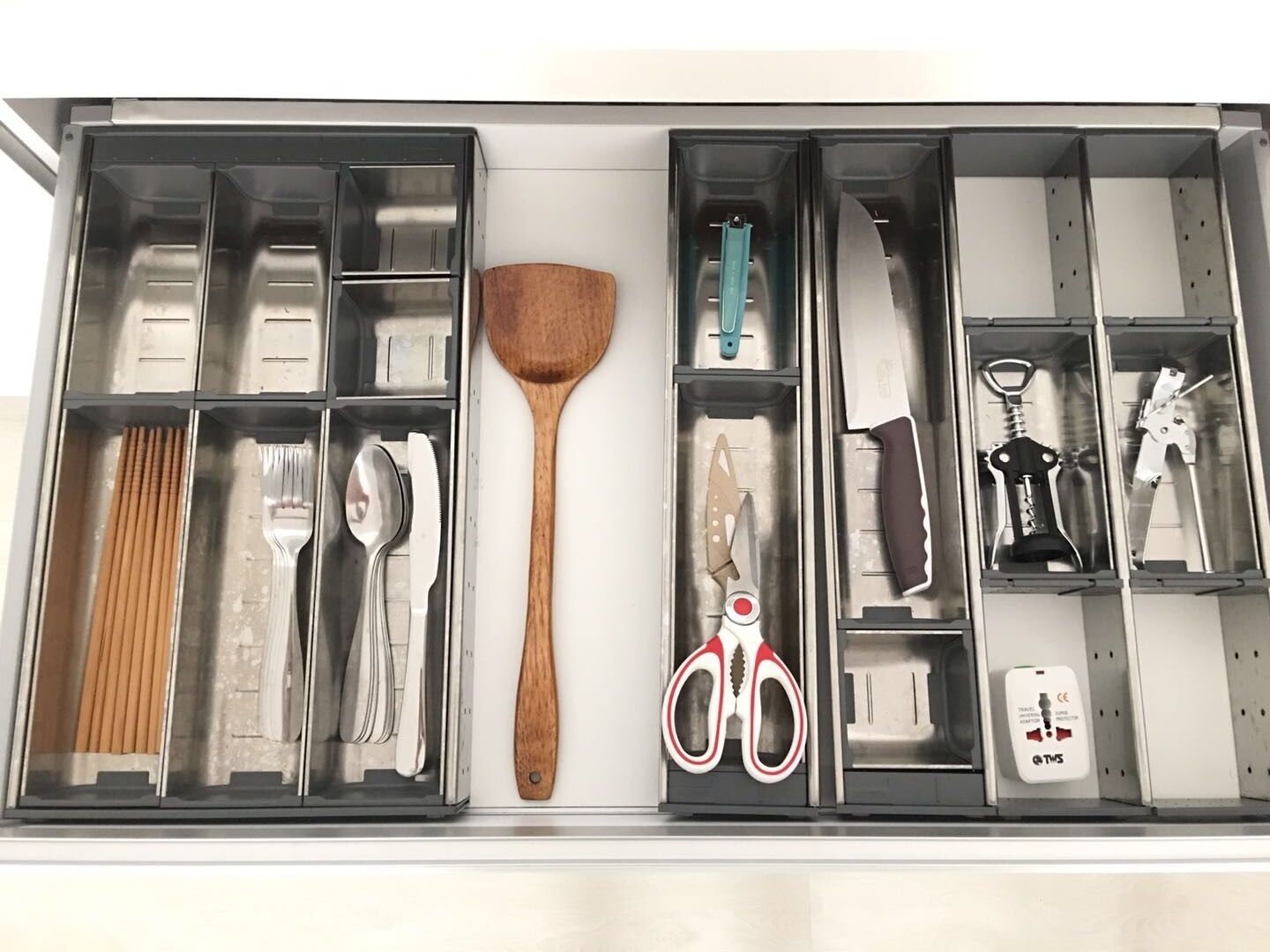 A kitchen drawer with utensils and appliances.