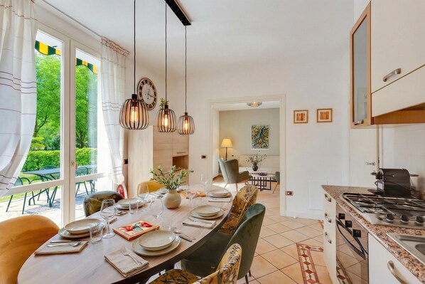 A modern kitchen with a dining area, large windows, and a view of the outdoors. - Porto Letizia Mimosa 1, Porlezza, Italy (Porlezza)