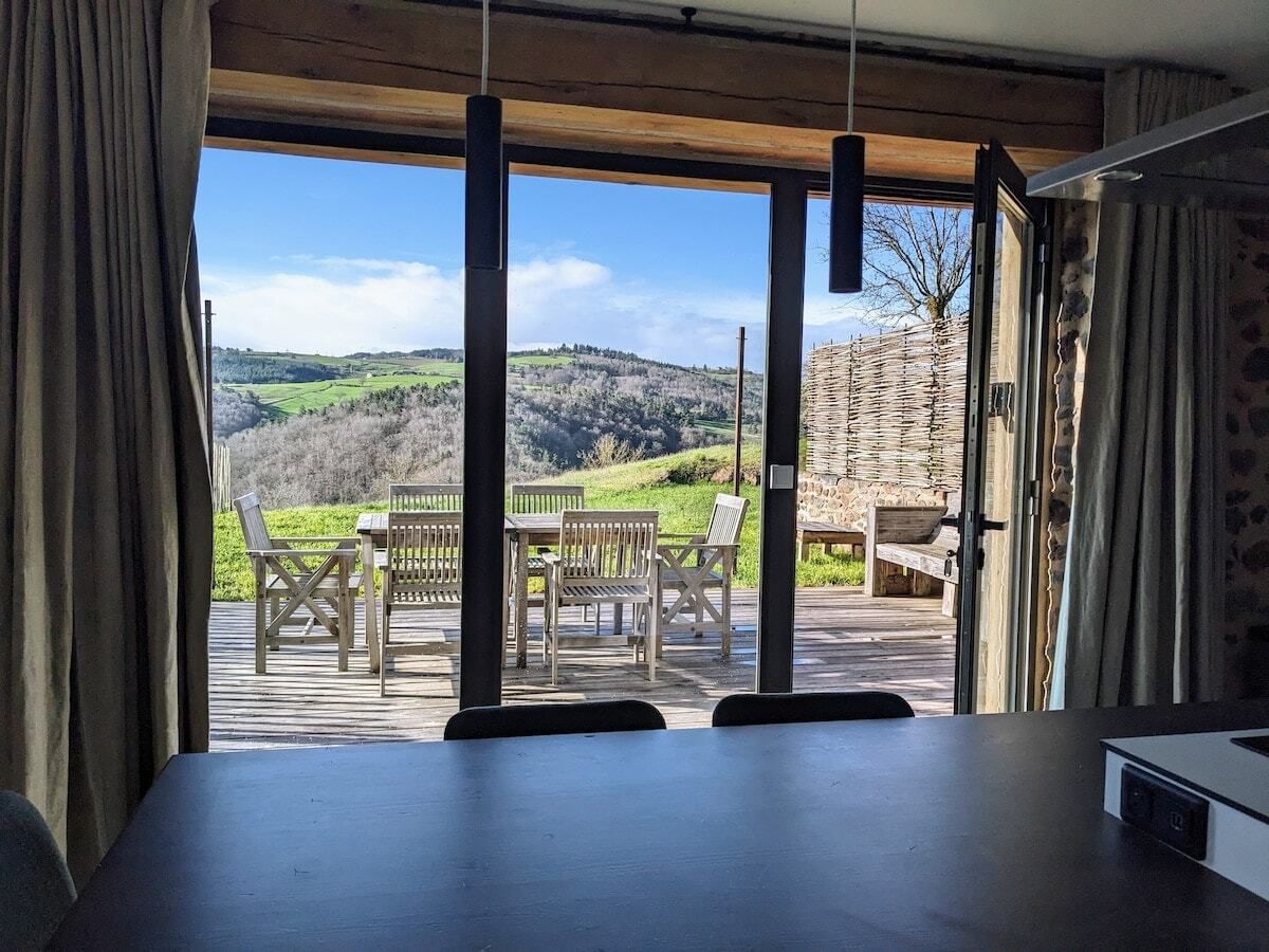 A room with a view of a wooden deck and outdoor furniture.