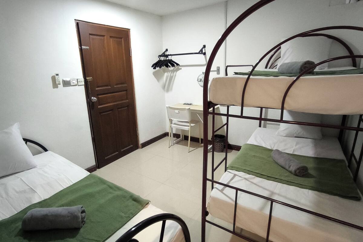 Ein Schlafsaalzimmer mit Etagenbetten, einem Schreibtisch und einem Stuhl.