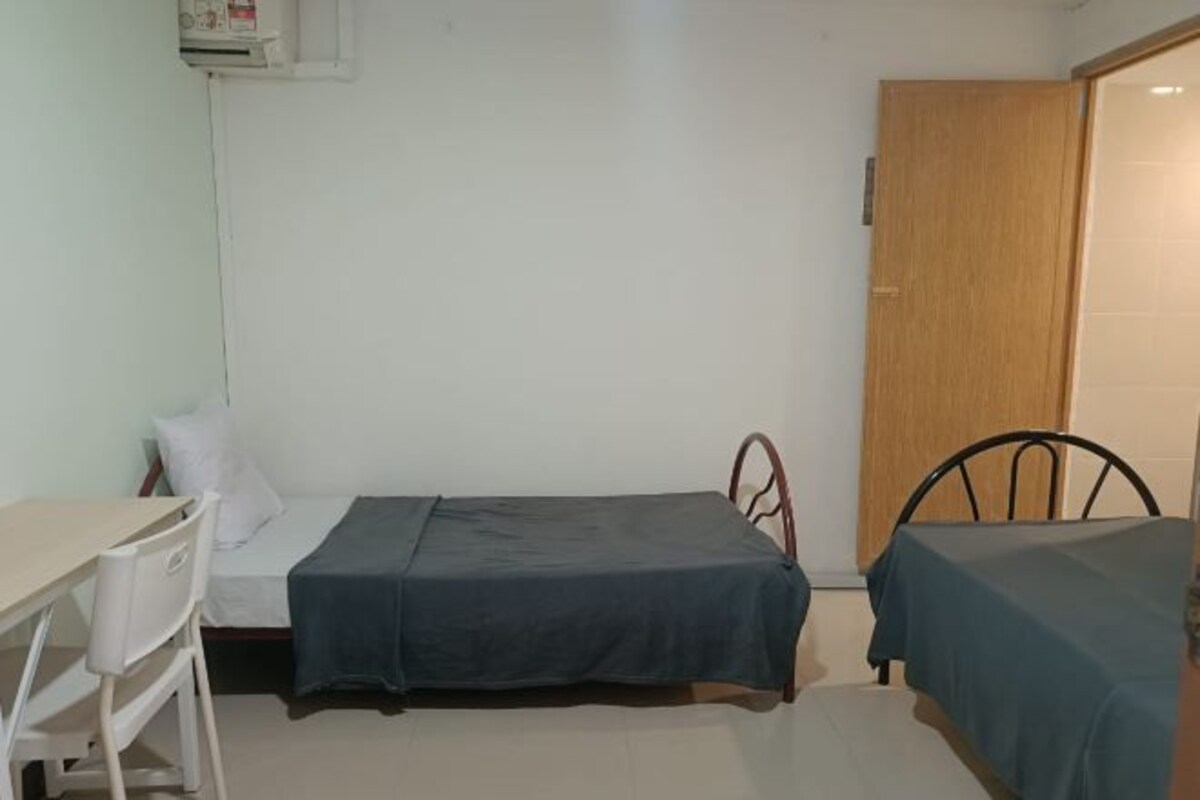 A room with a single bed, a desk, and a chair.