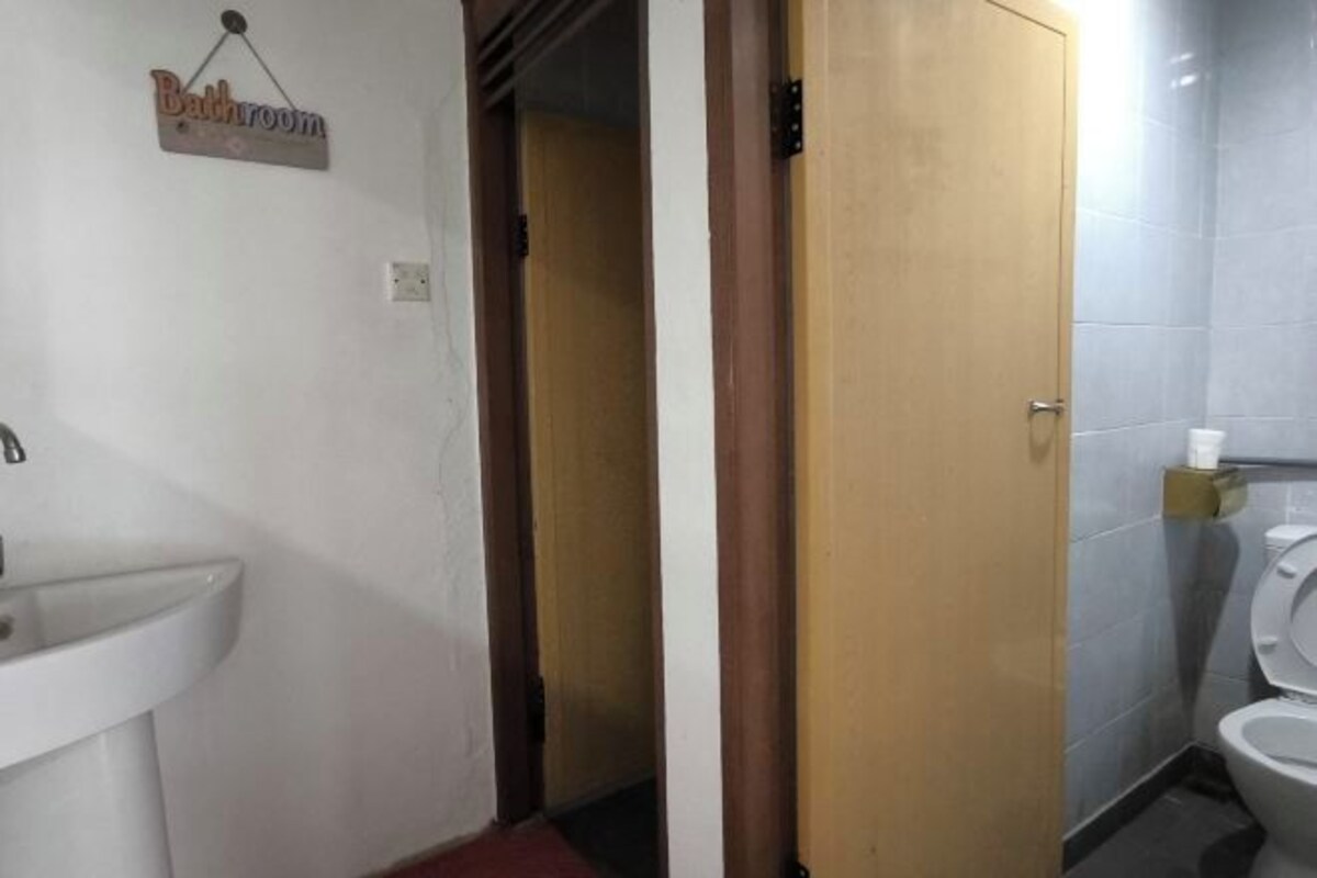 A bathroom with a sink, toilet, and a door leading to another room.