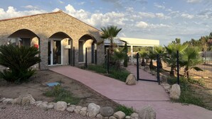 A stone building with arched doorways and a paved walkway leading to it. - les hameaux de saint cyprien (Lecci)