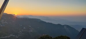 Un paysage montagneux au coucher du soleil.