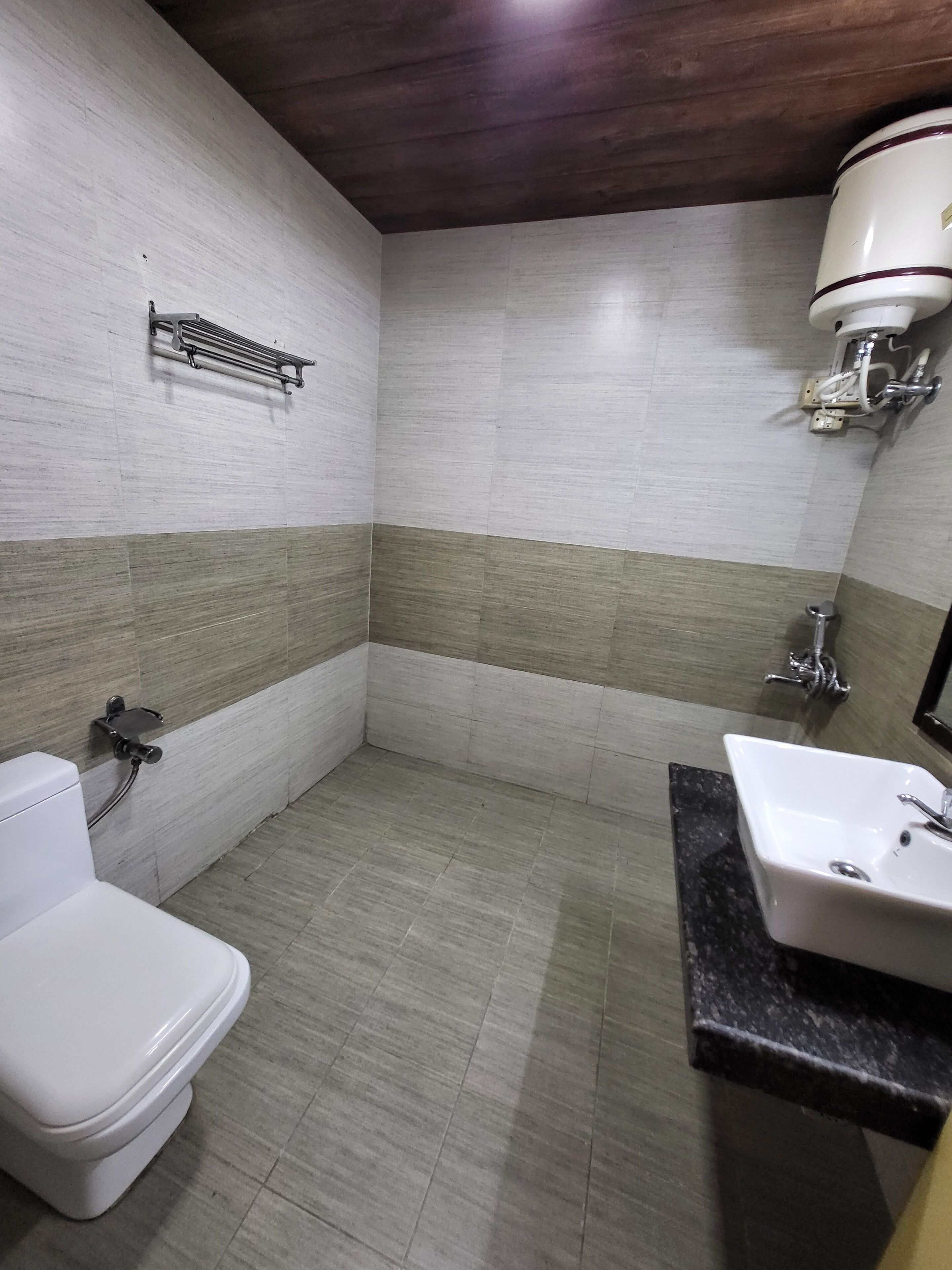 A bathroom with a toilet, sink, and shower area.