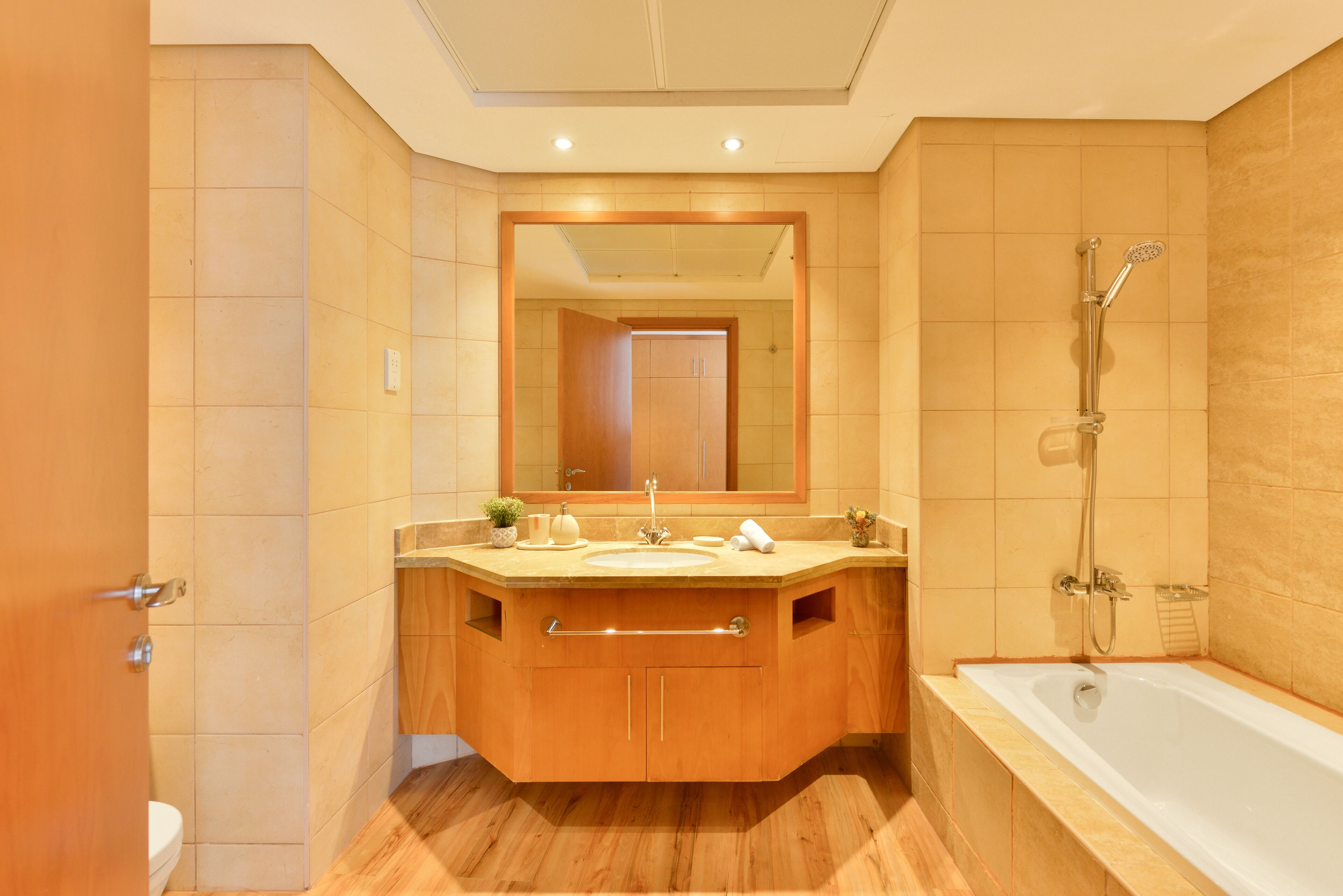 A modern bathroom with a wooden vanity, a large mirror, a bathtub, and a shower.