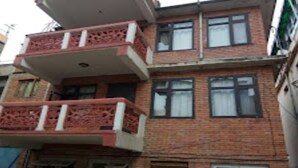 Un edificio de varios pisos con un balcón en el segundo piso.